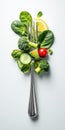 silver fork loaded with fresh, raw vegetables and a lemon slice, including spinach, broccoli, avocado, and a cherry tomato. A Royalty Free Stock Photo