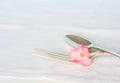 Sterling Fork and Spoon on Vintage White Table cloth with one Pink Rose Royalty Free Stock Photo