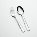 A silver fork and spoon are placed side by side on a plain white background. The fork Royalty Free Stock Photo