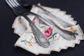 Silver fors on Embroidered kitchen napkin close up. Darck background. Royalty Free Stock Photo