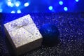 Silver gift box with a bow and hearts on a dark blue blurred background