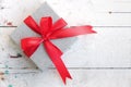 Silver gift box with red ribbon bow on vintage background Royalty Free Stock Photo