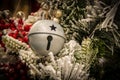 Silver gingle bell on flocked decorated Christmas tree - Christmas background - Selective focus Royalty Free Stock Photo