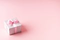 Silver glitter gift box with pink ribbon bow on pink background. Christmas, Valentine's day or birthday concept. Royalty Free Stock Photo