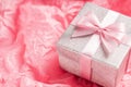 Silver glitter gift box with pink ribbon bow on pink background. Christmas, Valentine's day or birthday concept. Royalty Free Stock Photo