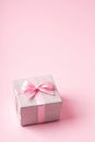 Silver glitter gift box with pink ribbon bow on pink background. Christmas, Valentine's day or birthday concept. Royalty Free Stock Photo