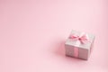 Silver glitter gift box with pink ribbon bow on pink background. Christmas, Valentine's day or birthday concept. Royalty Free Stock Photo