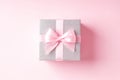 Silver glitter gift box with pink ribbon bow on pink background. Royalty Free Stock Photo