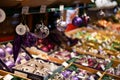 Silver glittered purple Christmas ornaments hanging from shelf in store at Christmas fair in Europe. Blurred background of boxes Royalty Free Stock Photo