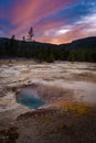 Silver Globe Cave Geyser at Biscuit basin with blue steamy water and beautiful colorful sunset. Yellowstone, Wyoming