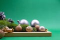 Silver and gold balls, walnut, acorn with spruce branches on pedestal on green background. Christmas, New Year