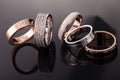 Silver, gold, platinum rings of different styles on the dark background of reflections