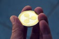 Silver gold ripple coin in hand, cryptocurrency investing concept