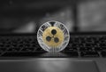 Silver gold ripple coin on a laptop keyboard closeup. Blockchain mining. Digital money and virtual cryptocurrency