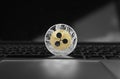 Silver gold ripple coin on a laptop keyboard closeup. Blockchain mining. Digital money and virtual cryptocurrency