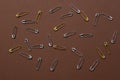 Silver and gold safety pins neatly placed on dark-brown background all over photo. Copy space. Mock up photography Royalty Free Stock Photo