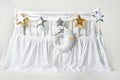 Silver, gold and white star shaped pillows and sleeping moon cushion on a white baby cot Royalty Free Stock Photo