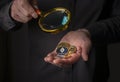 Silver and golden coins of cryptocurrency in male hand palm over black background, close up. Pile of ethereum, monero