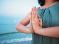 Silver and golden flash tattoo on female hands over sea or ocean background. Woman practicing yoga. Namaste