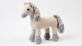Grey And White Knitted Pony Toy On White Background