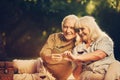 Silver haired cheerful twosome making photo outdoors