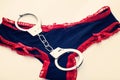 Silver handcuffs on black and red lace panties Royalty Free Stock Photo