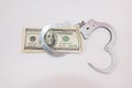 Silver handcuffs and us dollars on white, crime concept Royalty Free Stock Photo
