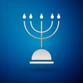 Silver Hanukkah menorah icon isolated on blue background. Hanukkah traditional symbol. Holiday religion, jewish festival Royalty Free Stock Photo