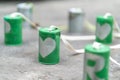 Silver heart on green cans connected with rope on cement floor. Royalty Free Stock Photo