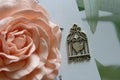 Silver Pendant, Heart-shaped Amulet In A Cage On The Background Of A Blooming Rose