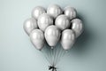 Silver helium balloons in a bundle on a gray background