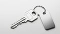Silver house key with blank metal tag on a white background Royalty Free Stock Photo