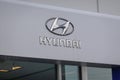 Silver Hyundai logo on a gray wall of a automobile dealership