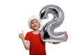 Silver inflatable ball number 2 in the hands of the boy in Santa hats. White background