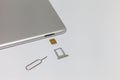 Silver inverted tablet. The SIM card tray is open. Royalty Free Stock Photo