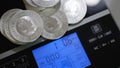 Pile of silver investment coins weighing on precise digital scales