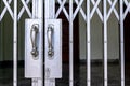 Silver iron fence entrance locked with classic metallic door handle