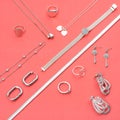 Silver jewelry on minimal pink background. Rings, bracelets and earrings. Top view of fashion woman accessories, jewelry and Royalty Free Stock Photo