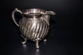 A silver jug, isolated, black background