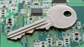 Silver key on electronic circuit board representing cybersecurity Royalty Free Stock Photo