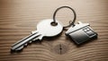 Silver Key with House Charm on Wooden Surface Royalty Free Stock Photo