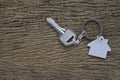 Silver key house with house shaped keychain on vintage wooden table background. Royalty Free Stock Photo