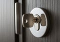 Of a silver key inserted into a modern, metallic keyhole set in a Royalty Free Stock Photo