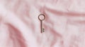 A silver key on a pink fabric. Royalty Free Stock Photo