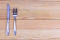 Silver knife and fork on wooden background. Cutlery on wooden board