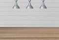 Silver lamps on the ceiling and a backdrop on a white wooden wall with brown wood floor.