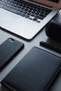 Silver Laptop with black phone, black notebook and black pen with speaker, close-up, top view, office, work Royalty Free Stock Photo