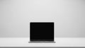 Silver laptop computer with a blank black screen placed on a white surface against a plain light grey background Royalty Free Stock Photo