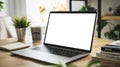 Silver laptop on stylish wooden table with open notebook, coffee cup, and stack of books for work and study in a cozy Royalty Free Stock Photo