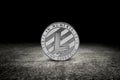 Silver litecoin coin on asphalt